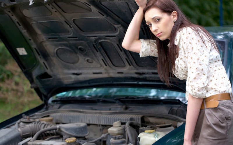 A sad woman whose car broke down showcases what to do when you are asking yourself whether you should repair or replace your car.