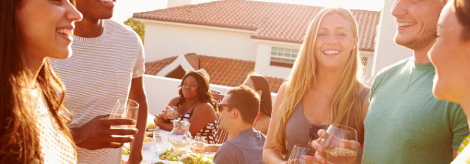 A multi-ethnic group of people at a party to illustrate the importance of social host liability.