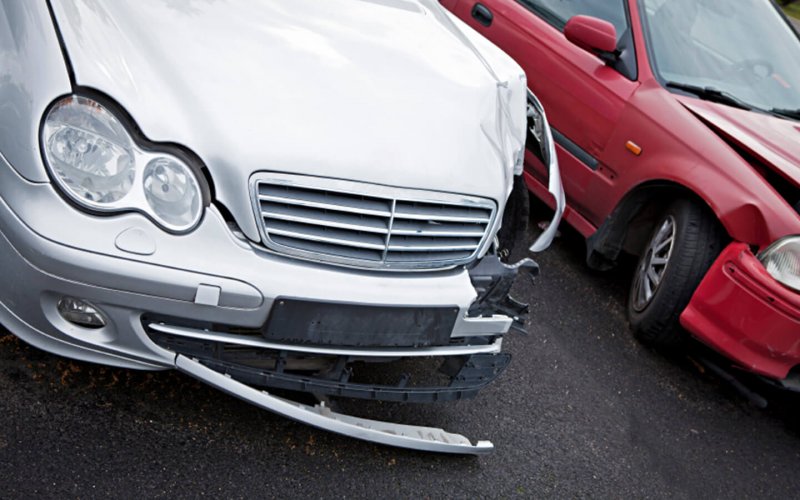 A car with a damaged bumper and a bent hood that illustrates the top 10 most common auto-insurance claims.
