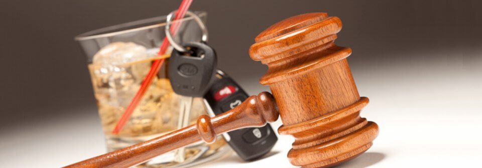 Car keys placed next to an alcoholic drink and a mallet that illustrate tips for buying auto-insurance after a DUI in California