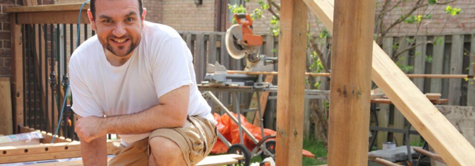 A middle-age Caucasian man working with wood in his backyard and portraying how DIY mistakes can impact your homeowner's insurance.