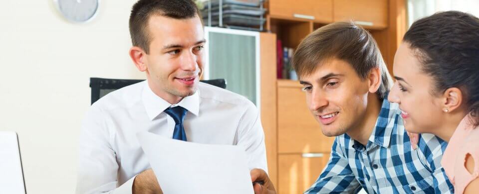 A young couple looking at the insurance premium that they received from a car insurance agent to illustrate how to talk to your insurance agent and save money on car insurance