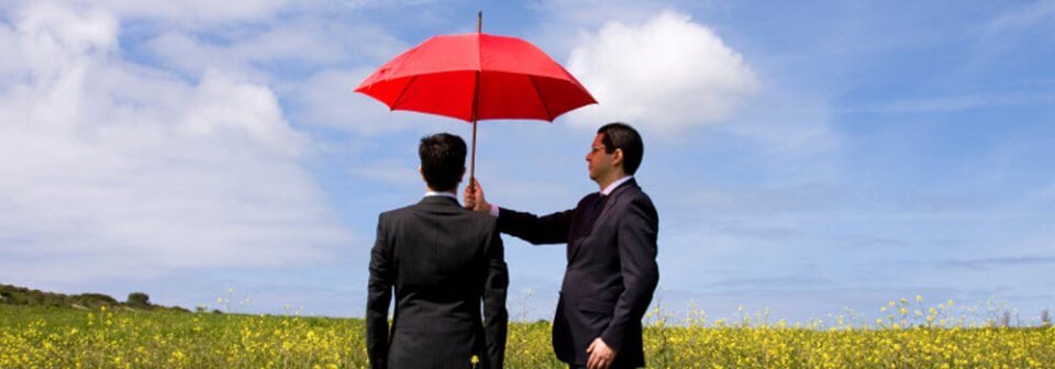 A man holding an umbrella for another man to illustrate why you should get umbrella insurance to save your future.