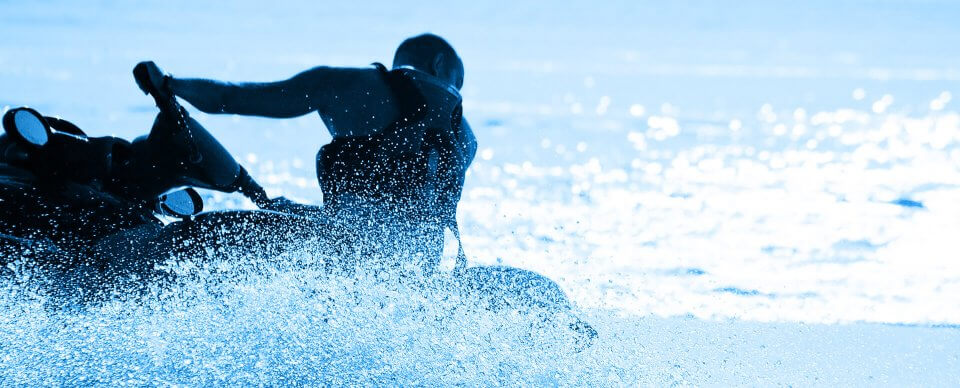 A man riding a jetski in the open sea to illustrate the importance of watercraft insurance.