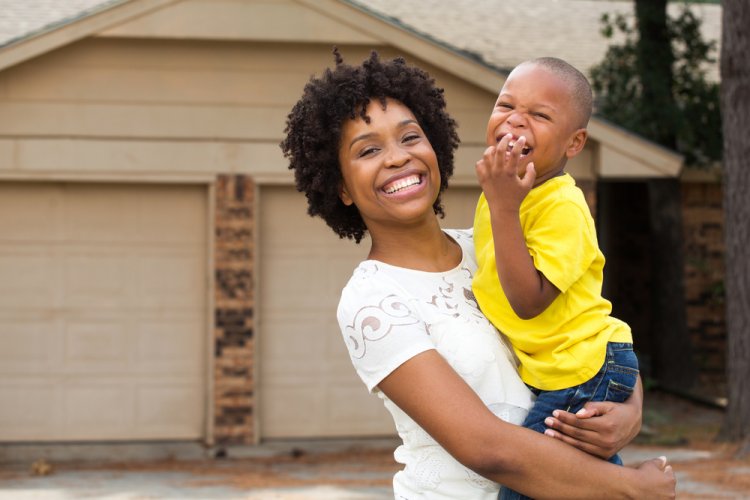 happy african american mother with child outside of home