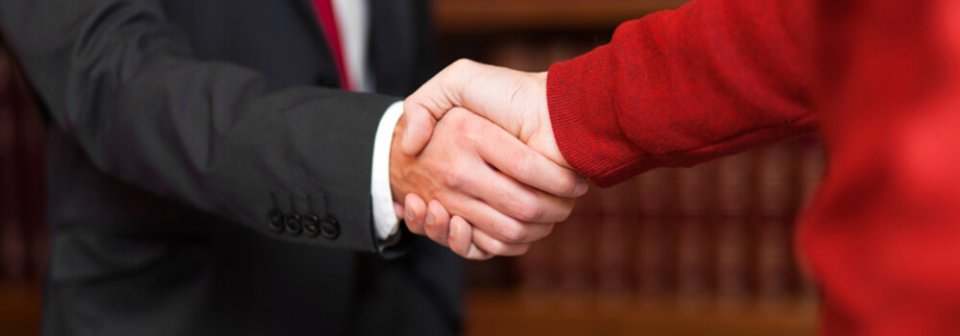 Two people shaking hands that illustrate whether you should hire an attorney to fight a traffic ticket.