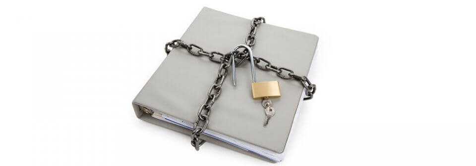 A closed binder surrounded with several chains and an open padlock to illustrate how to unlock the mystery of an SR-22 proof of coverage
