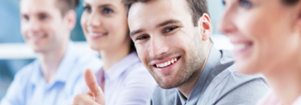 A Caucasian male smiling during a meeting because he purchased the right kind of coverage for his needs.