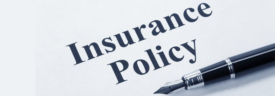 A document that reads Insurance policy and a fountain pen to illustrate what does most insurance cover