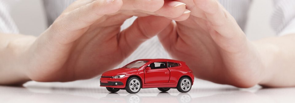 Close up to a pair of hands covering a toy car to illustrate what is auto liability coverage