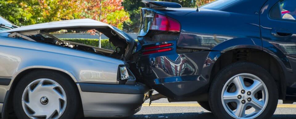 Close-up to the damage caused during a car crash to illustrate the importance of collision insurance.