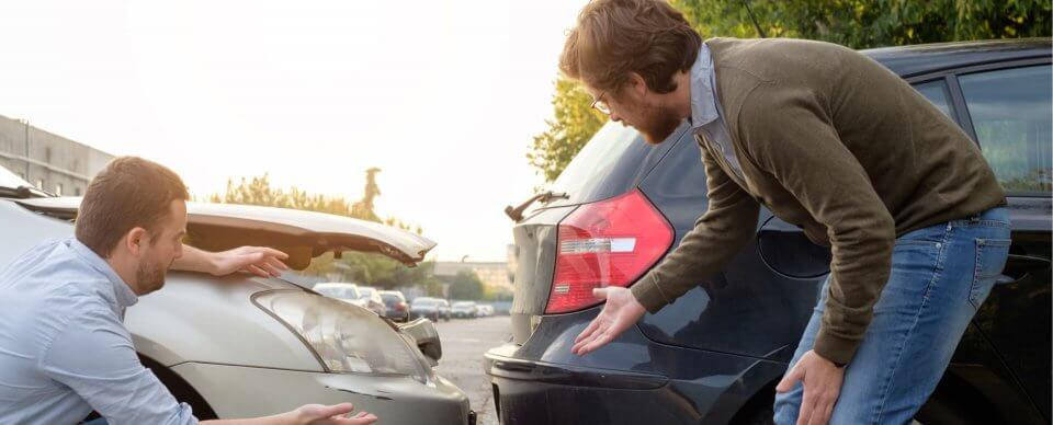 Two drivers arguing after a collision because one of them is uninsured.