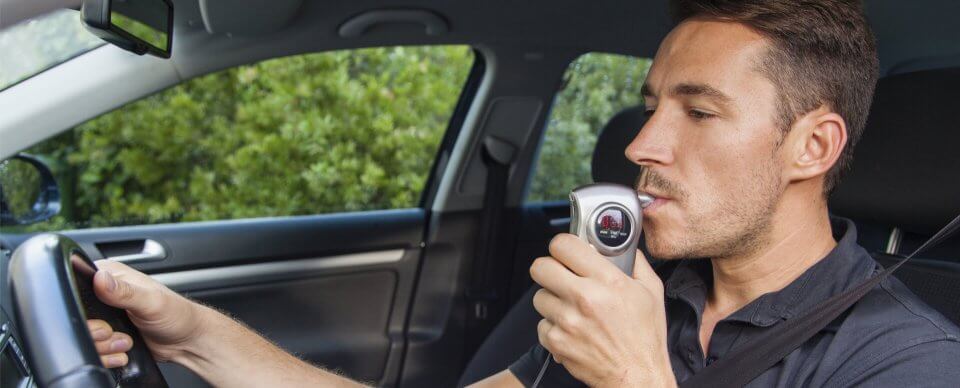 A man using an ignition-interlock device to start his car because he was involved in a DUI.