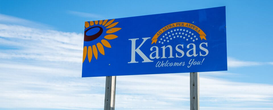 A road sign that reads Kansas Welcomes You! to illustrate the Kansas car insurance requirements.