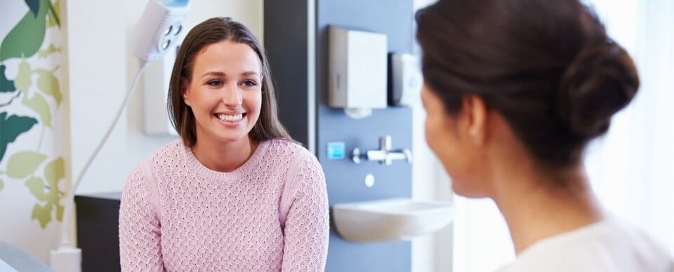 A young, Caucasian woman receiving medical care after learning how to get free or low-cost health insurance in California.