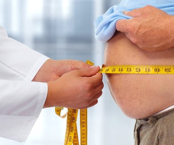 A doctor measuring the circumference of a man to illustrate health insurance for obese people