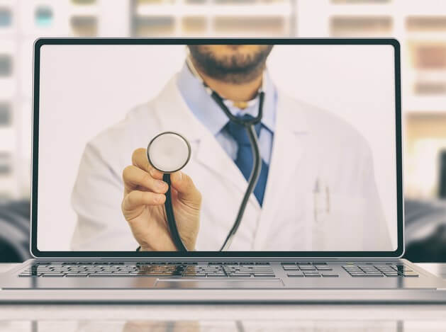 A physician showing a stethoscope to a webcam to showcase the telemedicine benefits.