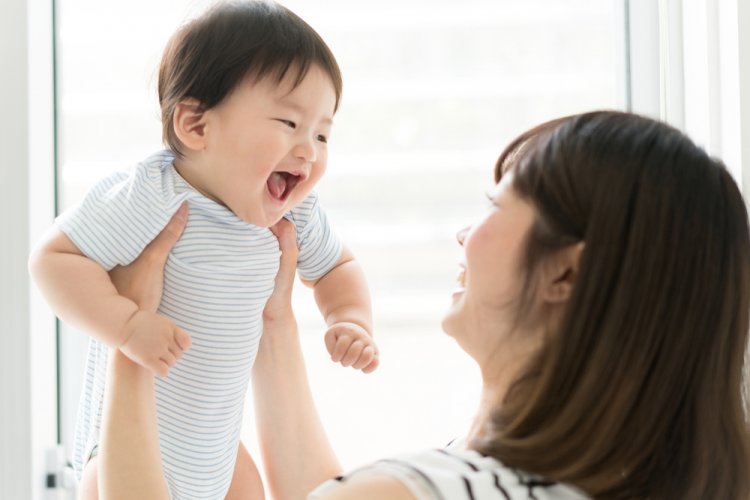 asian woman holding her newborn baby