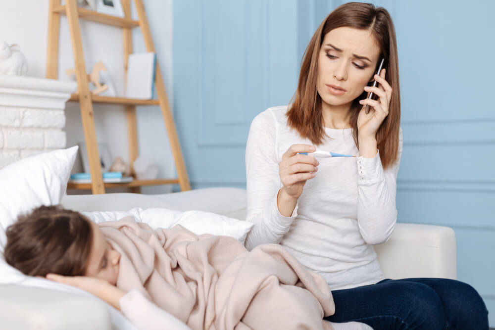 worried mother with sick child calling a doctor with telemedicine plan