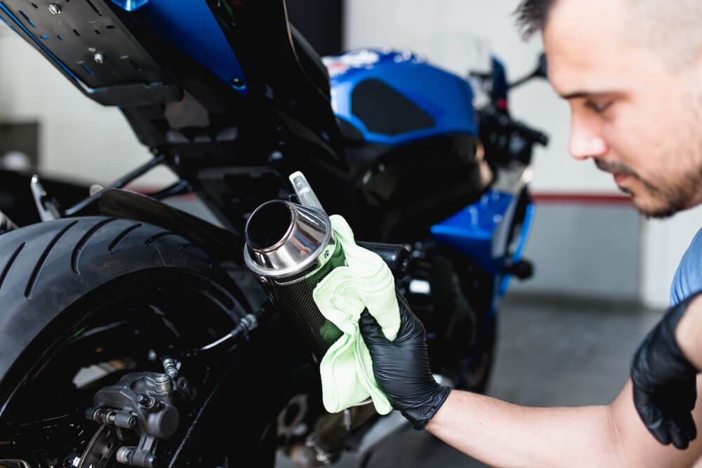 man cleaning his motorcycle for maintance