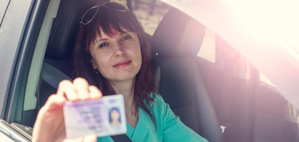 woman shows her license in car with sr 22 insurance