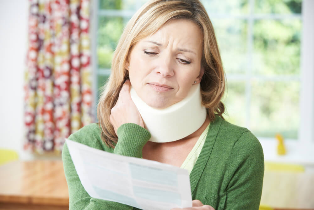 woman with a neck injury from a car accident looking at her medical bill