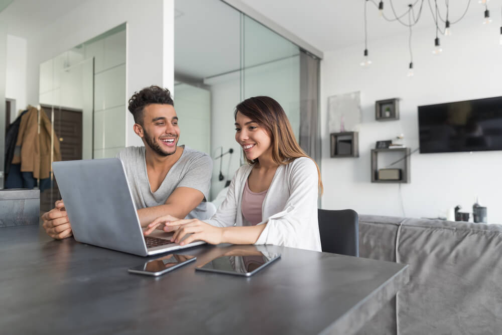 Couple Use Laptop Computer Sitting At Table to get family car insurance