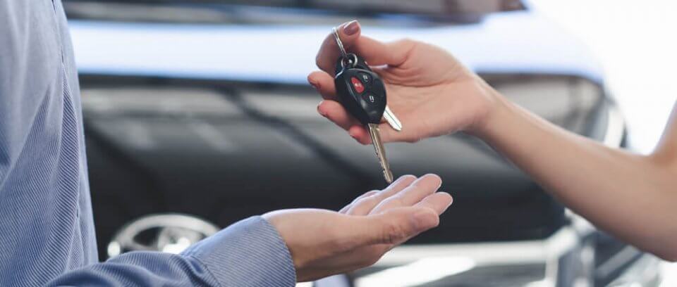 hand giving rental car keys to driver reimbursed by insurance company