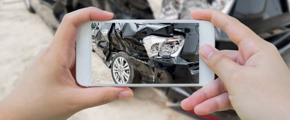 person taking picture of a car accident with an uninsured driver