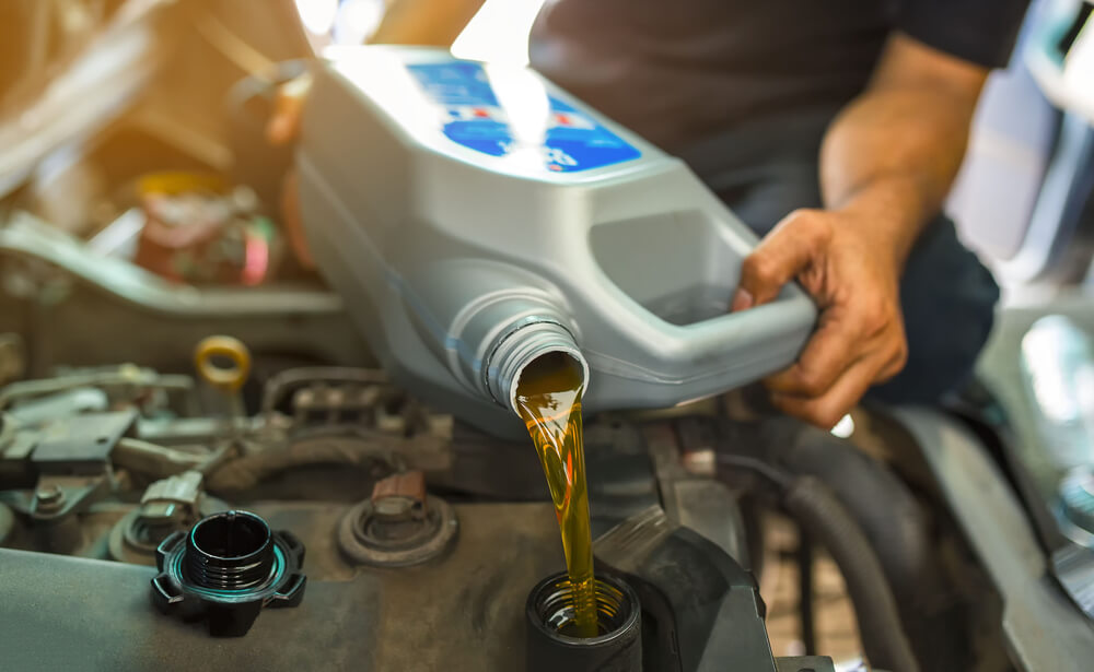 mechanic changing the oil on a car for maintenance