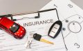 Car insurance form, keys, and a red toy car placed on paperwork, highlighting Texas Takes Worry Out of Producing Proof of Insurance.