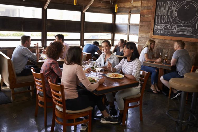 A group of friends gather for lunch together at a restaurant.