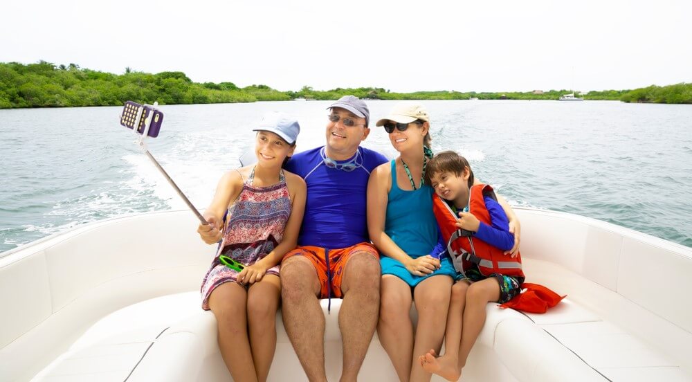 happy familiy taking a selfie on their boat with boat insurance