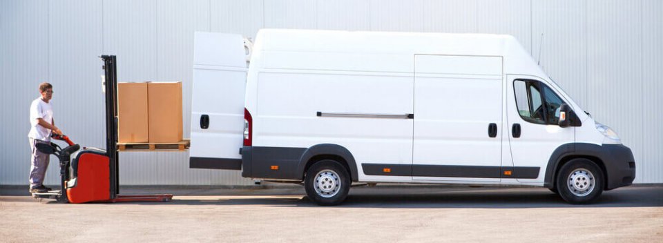 Photography of a man loading delivery boxes onto a delivery van with truck insurance.