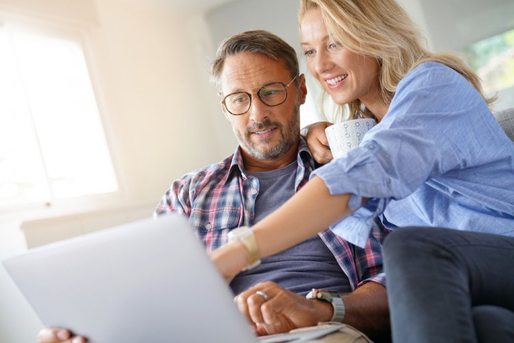 happy couple looking in laptop for renters insurance