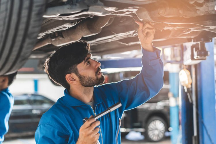 mechanic checking tire balance in car to illustrate what is routine maintenance on a vehicle