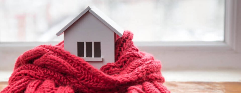 Photography of a small wooden toy house covered with a wool scarf