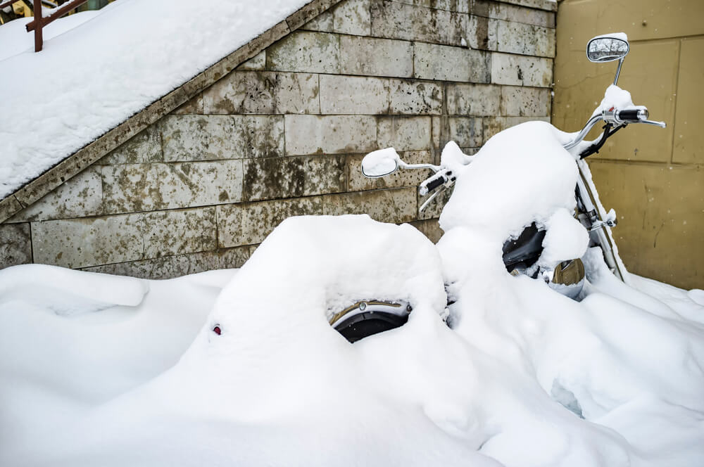 parked motorcycle buried in snow