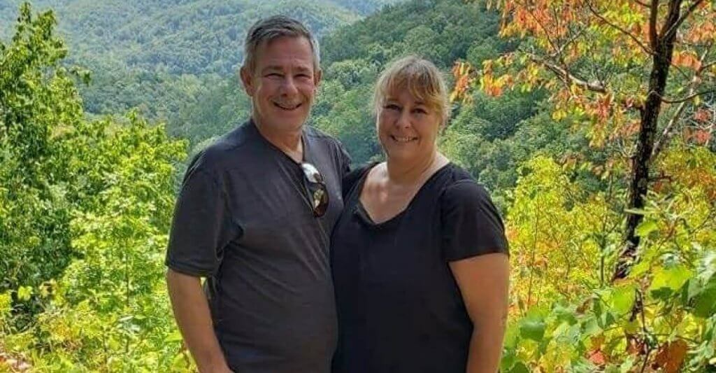 happy older couple with a nature background and the word love in fron