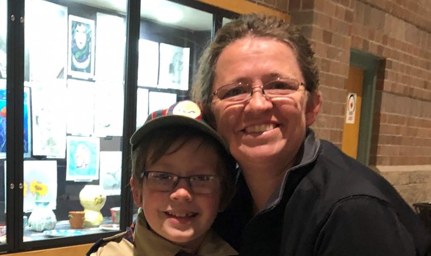 Portray of community heroine Nessa Kayden next to a child wearing a scouts uniform