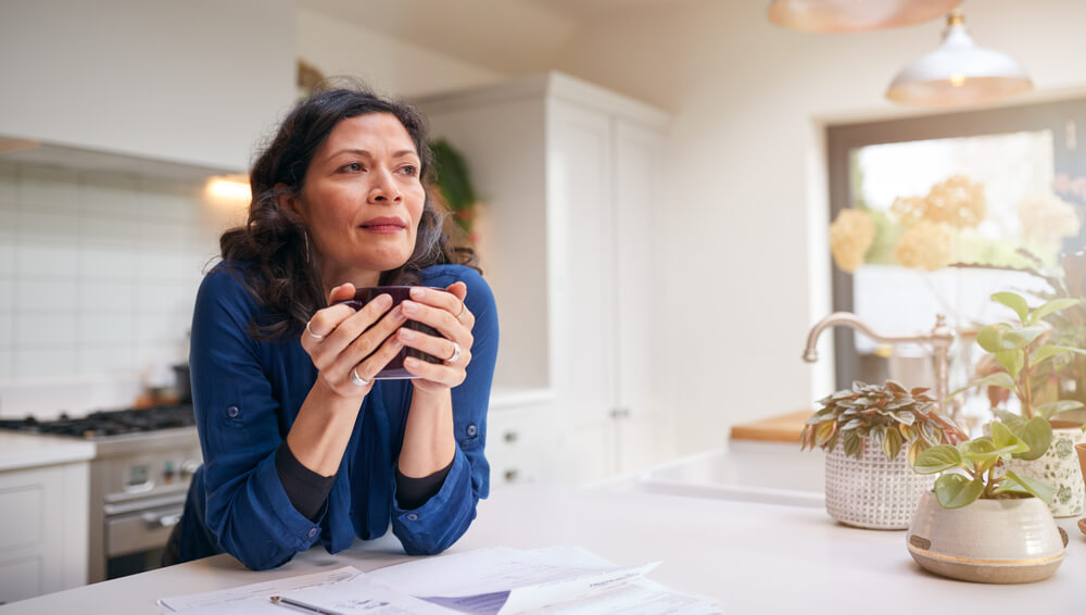older hispanic woman in her ktichen wondering about the types of life insurance