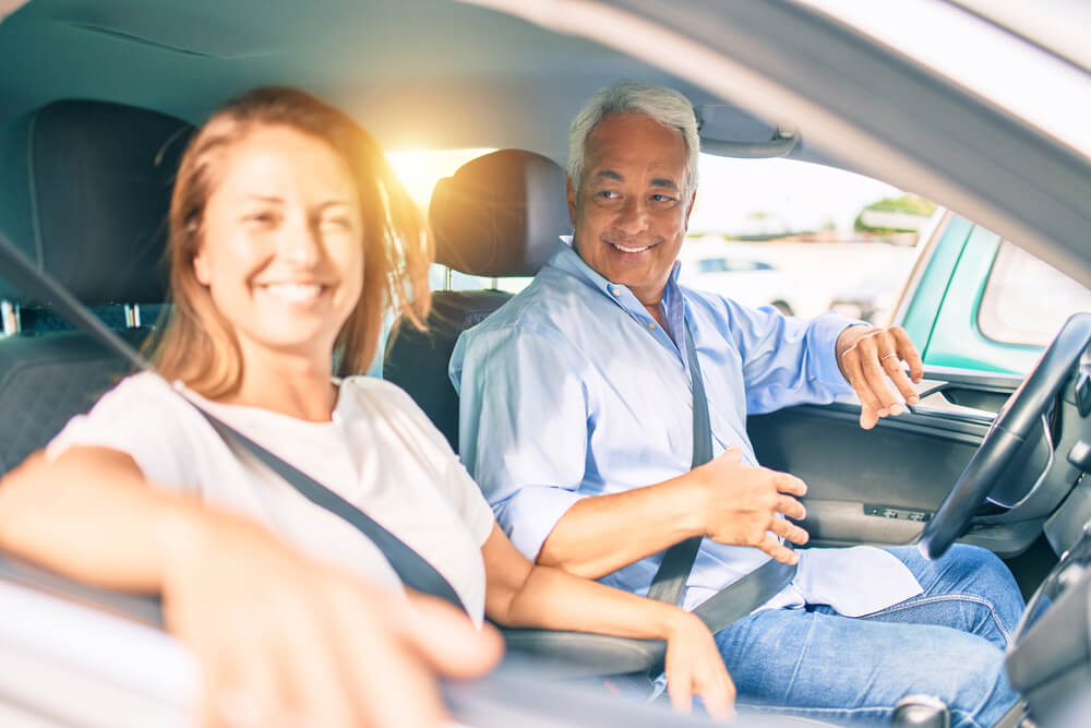 happy couple in car driving with insurance after a dui