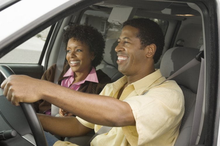 happy african american couple in car with insurance
