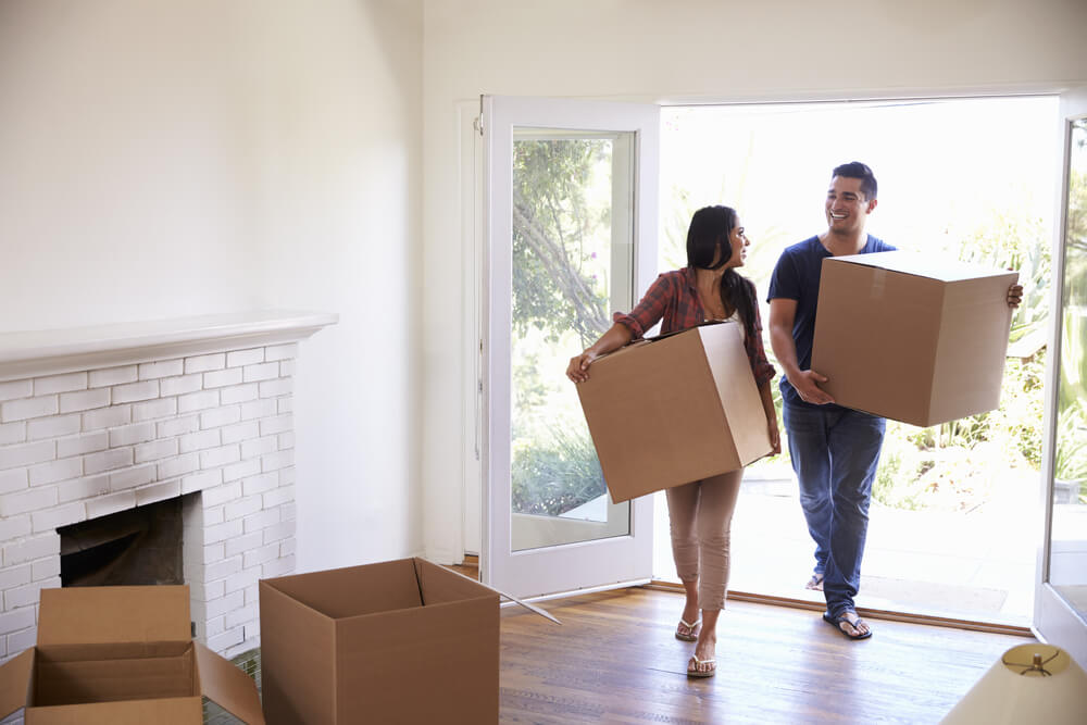 couple carrying boxes into their new home