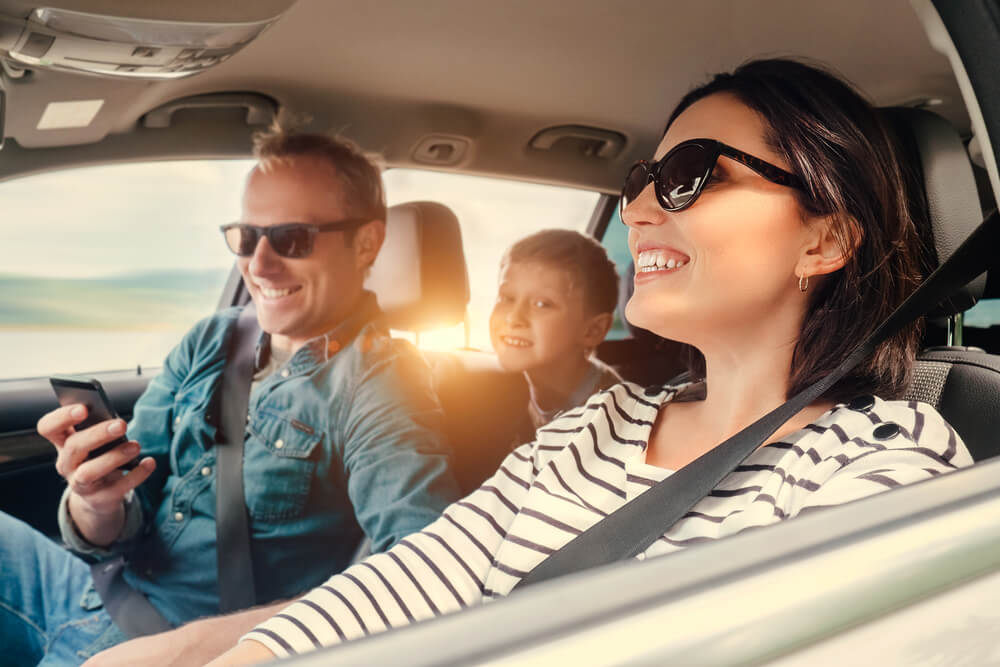 Happy family riding in a car with insurance