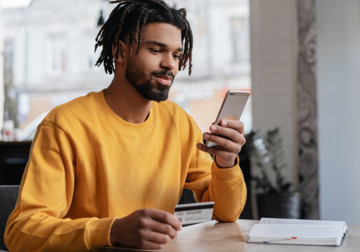 african american man looking in smartphone for car insurance