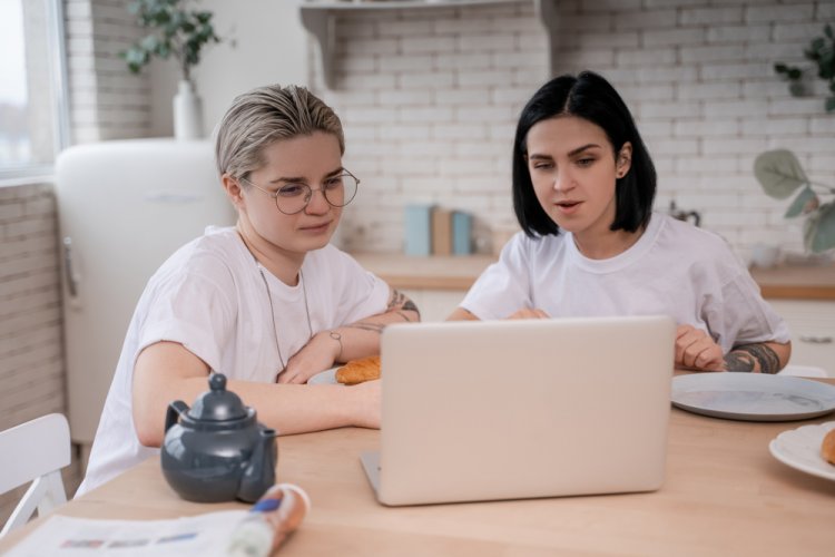 two women in kitchen looking at laptop for car insurance type