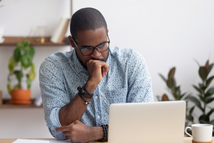 worried african american man looking at laptop for dui insurance