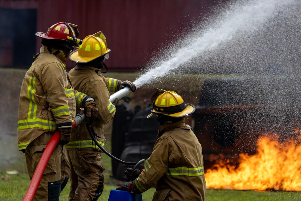 Firefighters battling a fire, highlighting emergency protection in a renters insurance guide