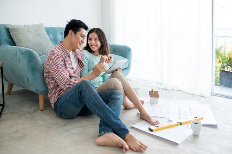 Attractive young asian adult couple planning new home design